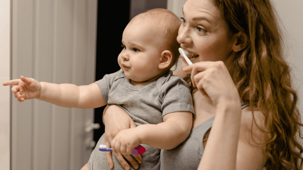 Young mom doing toothbrush with baby